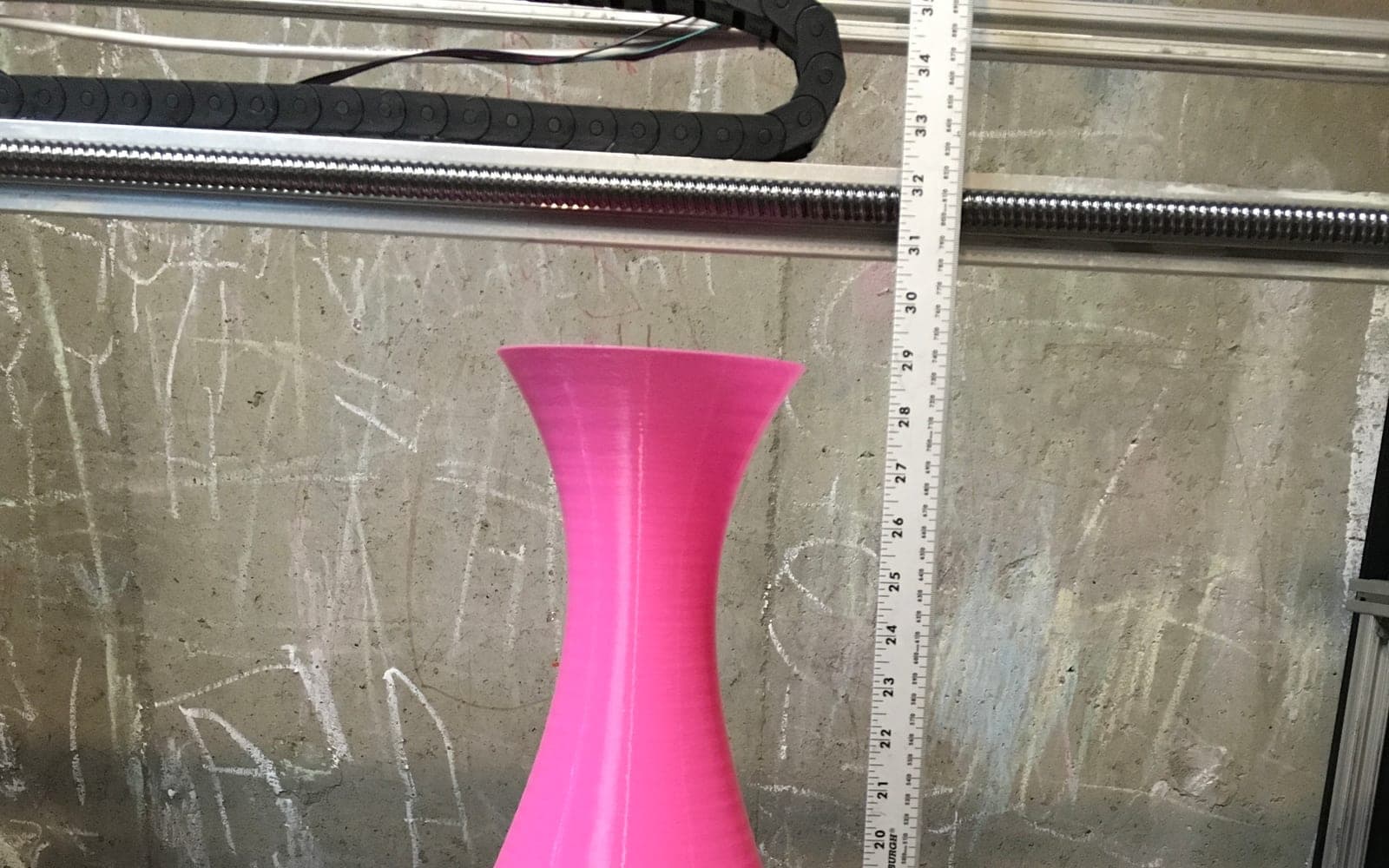 Large purple 3D printed part on a professional printer bed