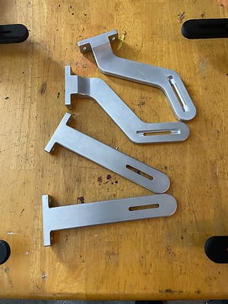 Functional bracket-style 3D printed parts arranged on a workbench